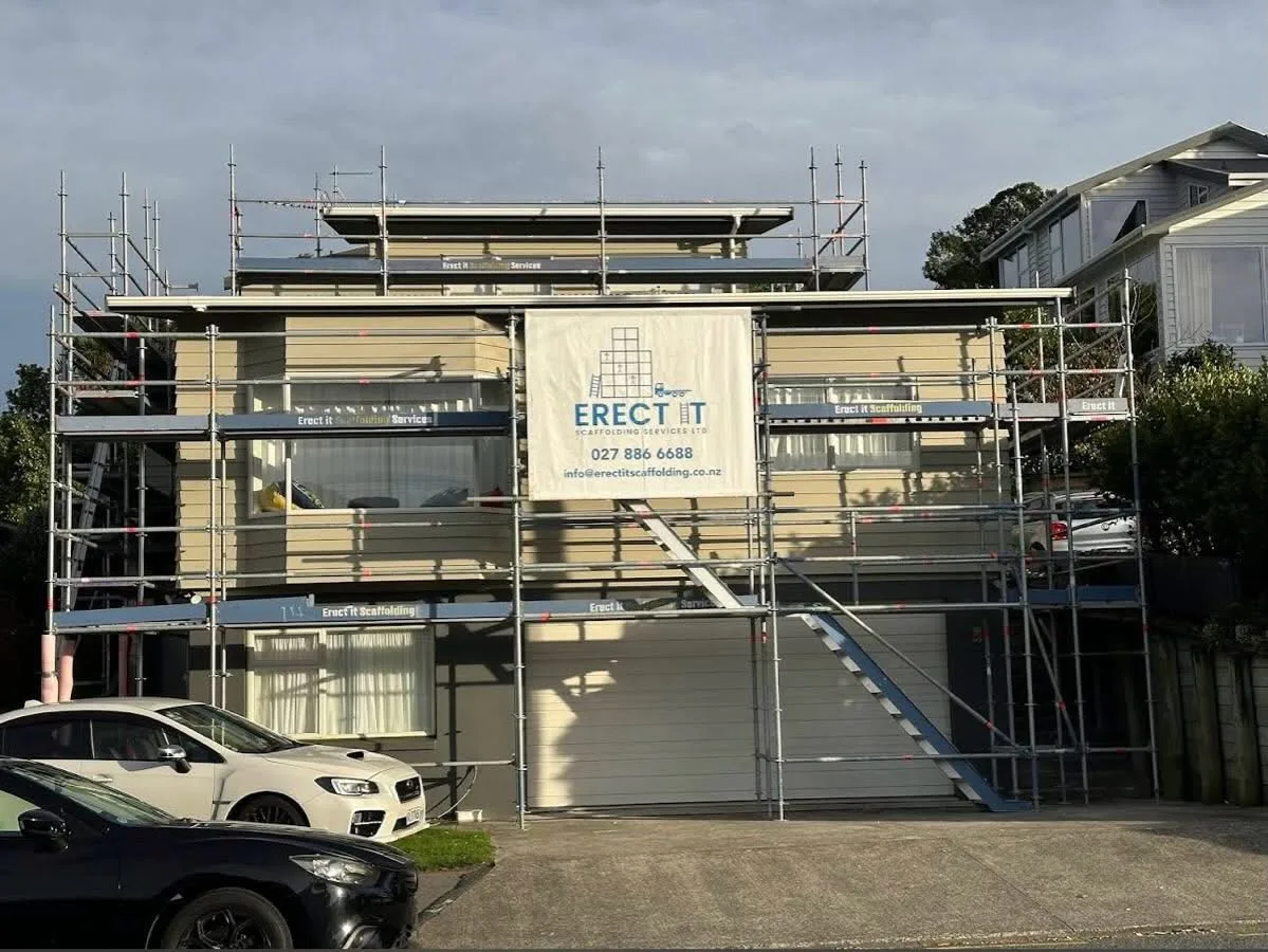 Full multi-level exterior painting scaffolding on a residential home in Plimmerton, Porirua — Erect It Scaffolding branded banners and safe access platforms