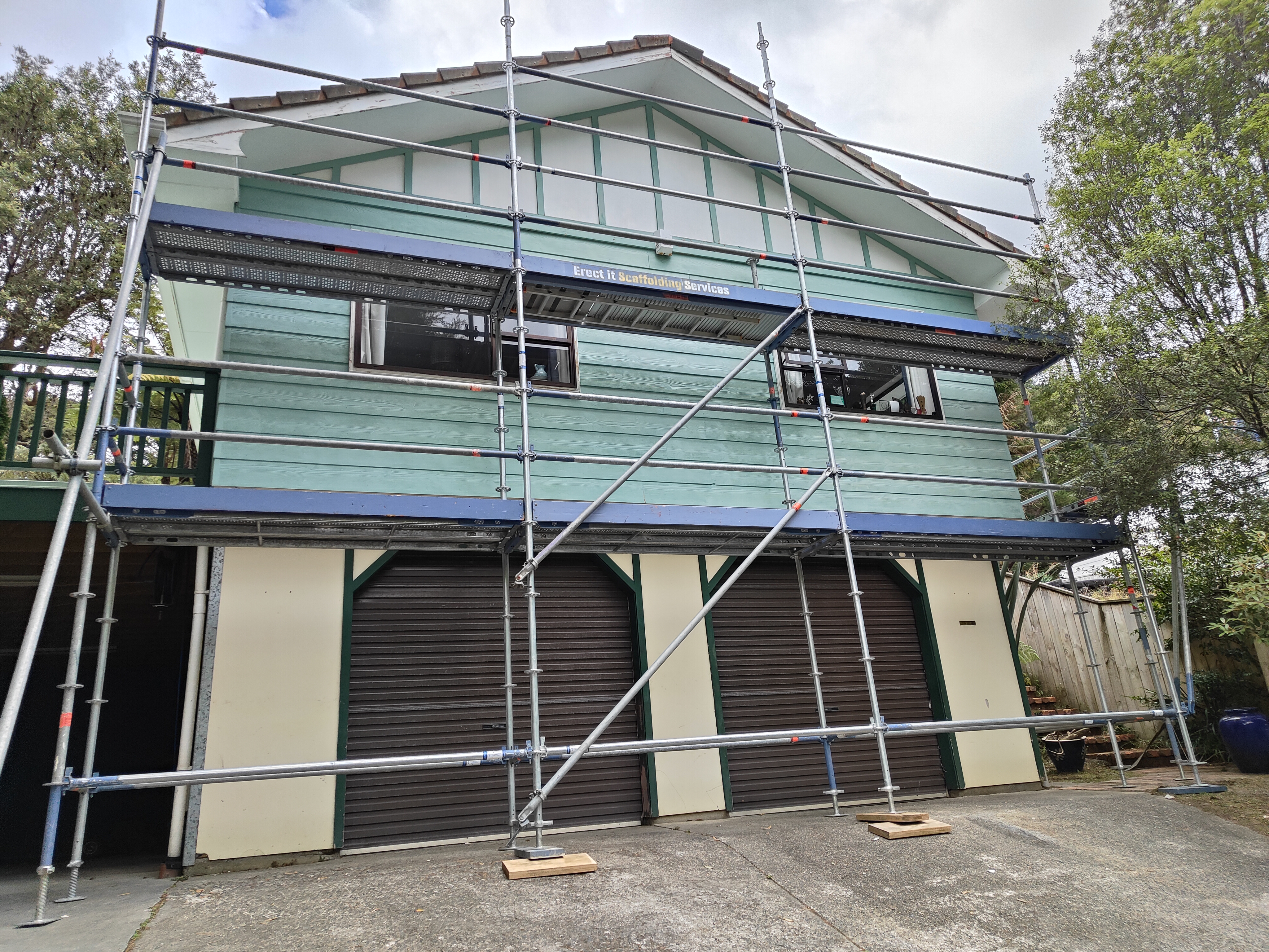Residential scaffolding for exterior repaint in Wainuiomata, Lower Hutt — two-storey scaffold with Erect It branding