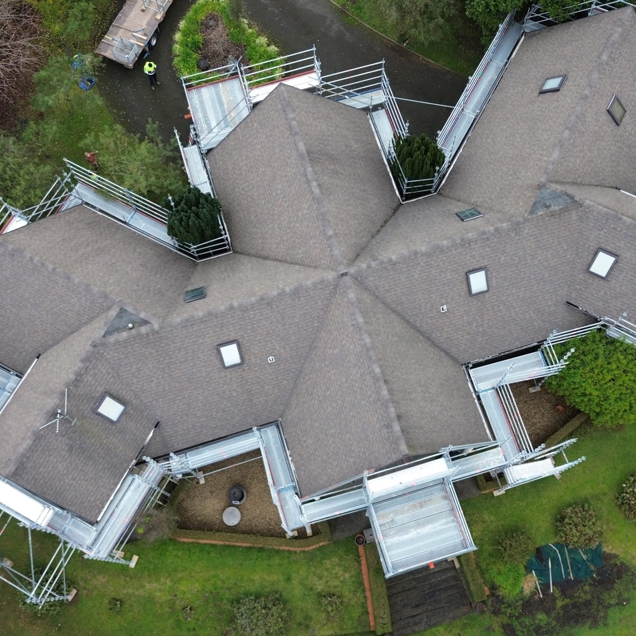 Detailed aerial view of safe scaffold working platforms and edge protection around a complex shingle roof in Waikanae