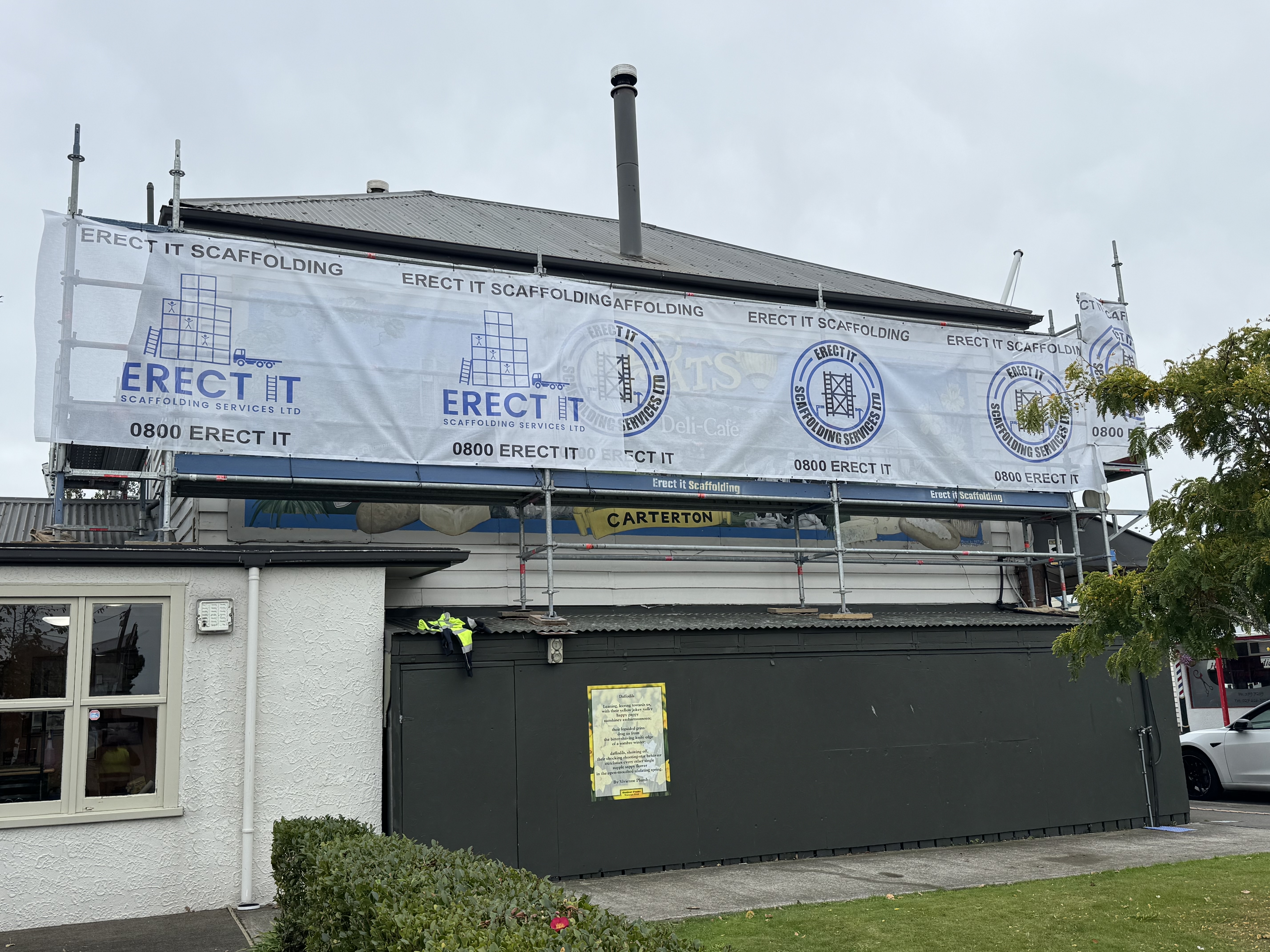 Erect It Scaffolding commercial scaffold installation at Wild Oats Cafe, Carterton, Wairarapa — branded banners and full perimeter access for exterior works